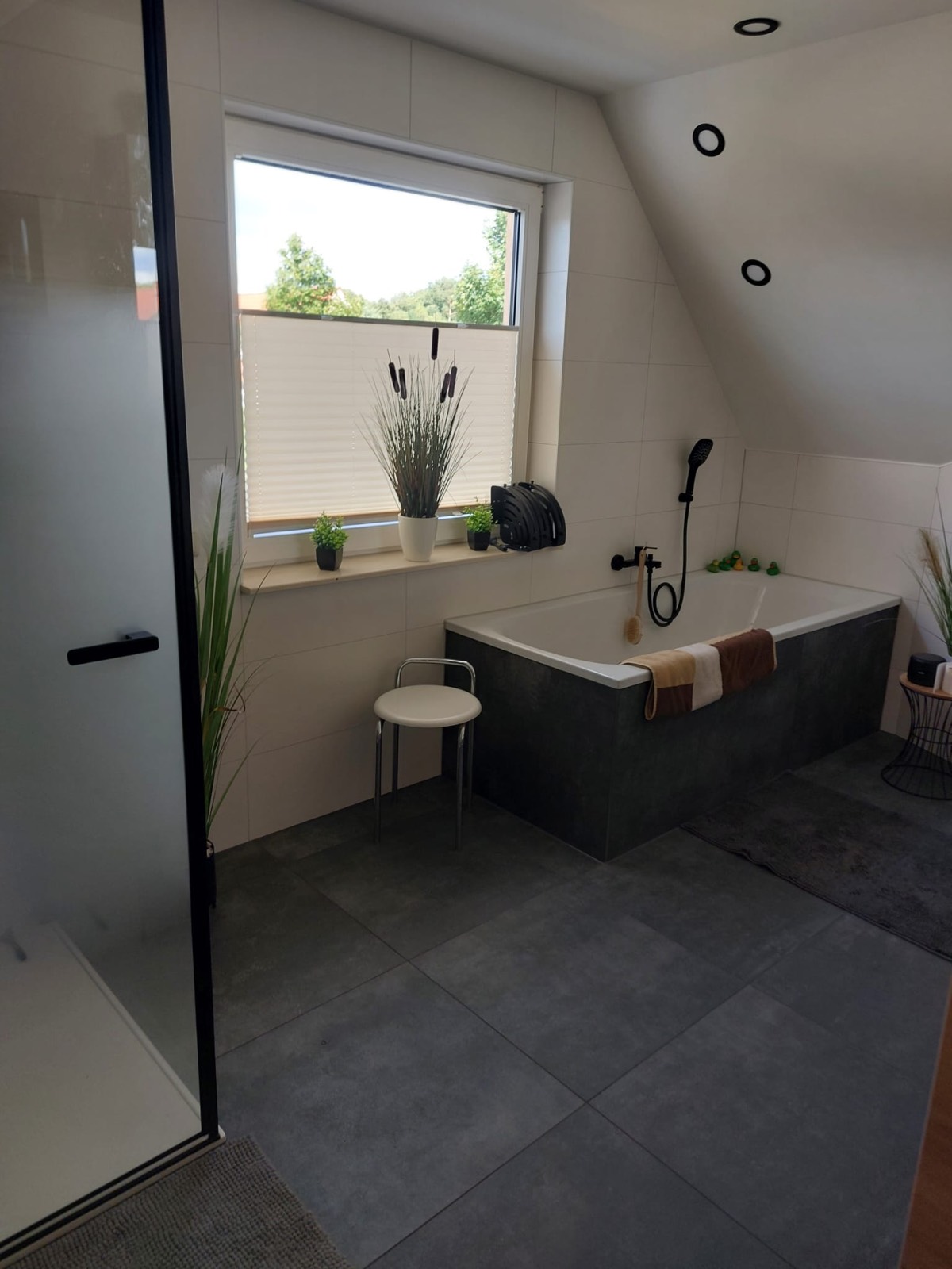 Badewanne mit Hocker und dekoriertem Fenster