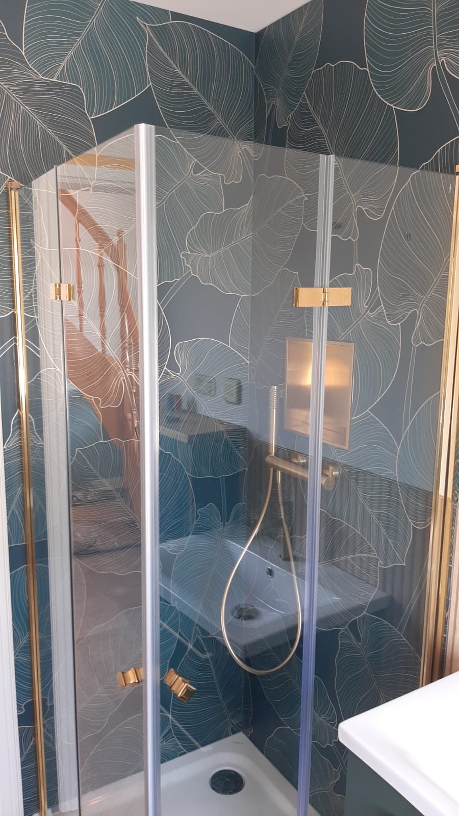 Dusche mit Blättermotiv an der Wand