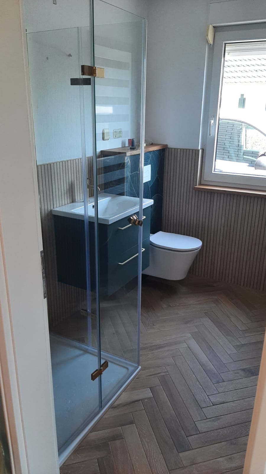 Dusche mit grünen Fliesen im Fischgrätmuster