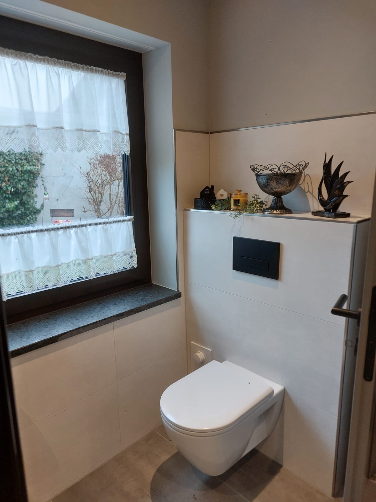 Gäste-WC mit Fenster und gefliester Wand